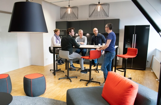 Mitarbeitende bei einer Unterhaltung in der Küche