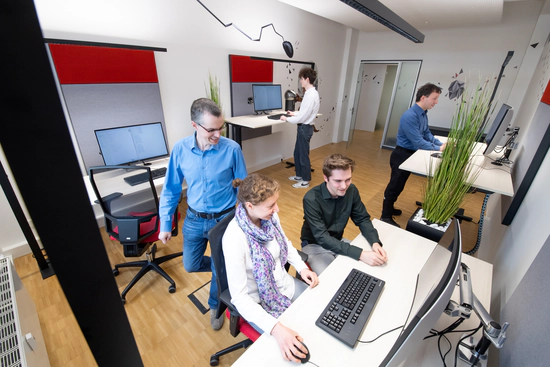 Mitarbeitende während der Arbeit im Teamraum