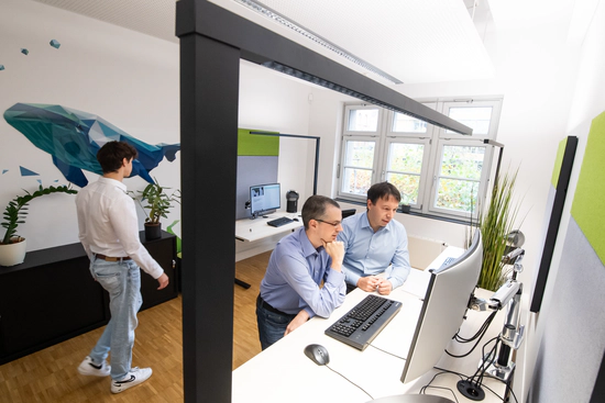 Mitarbeitende während der Arbeit im Teamraum